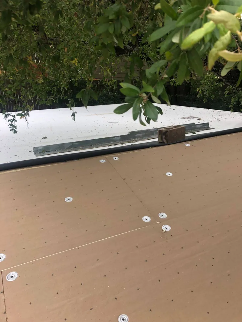 Professional roofing inspector checking seams on a massive industrial flat roof deck