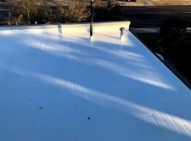 Wide view of a clean, newly completed commercial flat TPO roof on an office complex in Austin